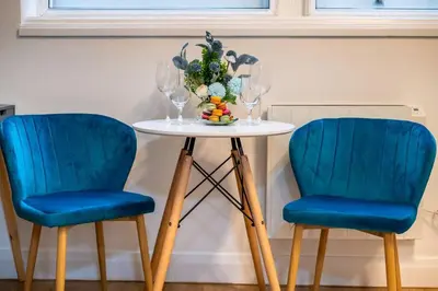 two blue chairs next to a table with a vase on it at Charming Apartment in Liverpool City Centre - Peaceful Sleep! in Liverpool