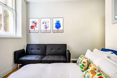 a bedroom with a couch and paintings on the wall at Charming Apartment in Liverpool City Centre - Peaceful Sleep! in Liverpool