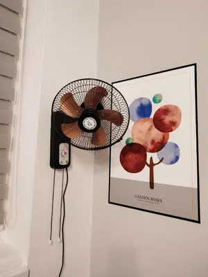 a fan hanging on a wall next to a picture at Charming Apartment in Liverpool City Centre - Peaceful Sleep! in Liverpool