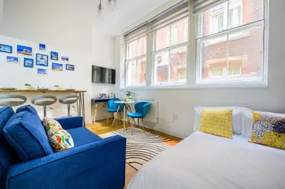 a living room with a blue couch and a table at Charming Apartment in Liverpool City Centre - Peaceful Sleep! in Liverpool