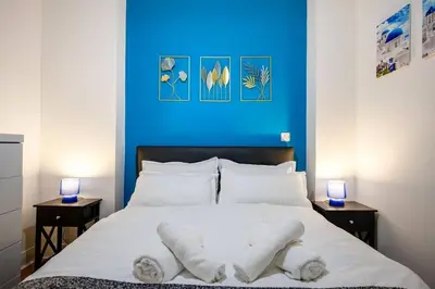 a bedroom with a blue wall and a bed with towels at Charming Apartment in Liverpool City Centre - Peaceful Sleep! in Liverpool