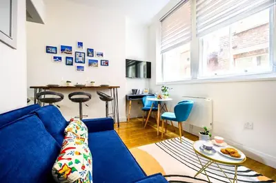 a living room with a blue couch and a table at Charming Apartment in Liverpool City Centre - Peaceful Sleep! in Liverpool