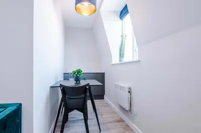 a small table in a small room with a window at Elysée Suites - Chic 1 Bed Flat in Southport in Southport