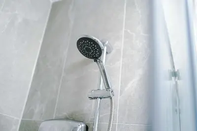 a shower with a shower head in a bathroom at Elysée Suites - Chic 1 Bed Flat in Southport in Southport