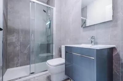 a bathroom with a toilet and a sink and a shower at Elysée Suites - Spacious Studio in Southport in Southport