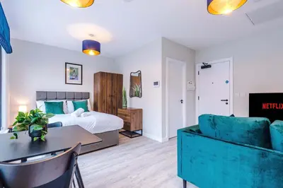 a hotel room with a bed and a table at Elysée Suites - Spacious Studio in Southport in Southport