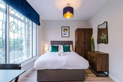 a bedroom with a bed and a large window at Elysée Suites - Spacious Studio in Southport in Southport
