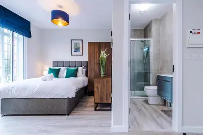 a bedroom with a large bed and a bathroom at Elysée Suites - Spacious Studio in Southport in Southport