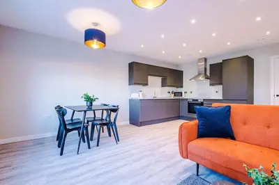 a living room with a couch and a table and chairs at Elysée Suites - Stunning 2 Bed Flat in Southport in Southport