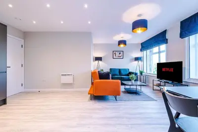 a living room with a couch and a tv at Elysée Suites - Stunning 2 Bed Flat in Southport in Southport