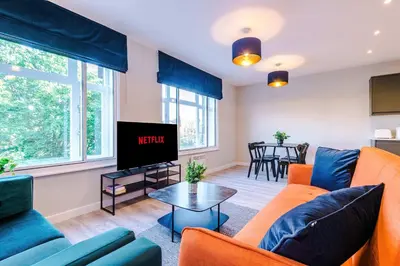a living room with a couch and a tv at Elysée Suites - Stunning 2 Bed Flat in Southport in Southport