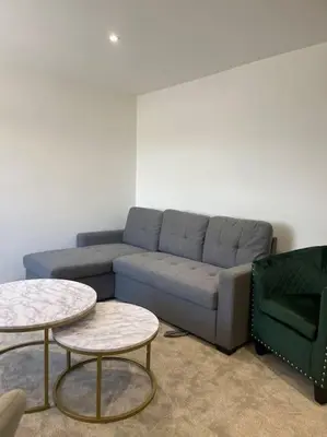 a living room with a couch and two tables at Balmoral Stays 6 - Studio Apartment by Pleasure Beach in Blackpool