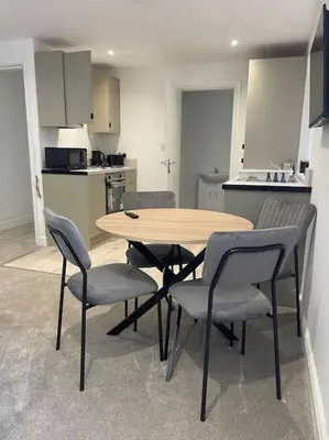 a kitchen with a wooden table and chairs in a room at Balmoral Stays 6 - Studio Apartment by Pleasure Beach in Blackpool