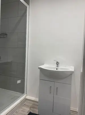 a white bathroom with a sink and a shower at Balmoral Stays 6 - Studio Apartment by Pleasure Beach in Blackpool
