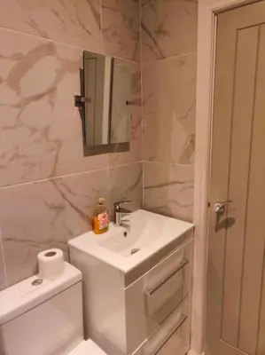 a bathroom with a sink and a toilet and a mirror at Sloane modern 2 bedroom seafront Apartment in Blackpool