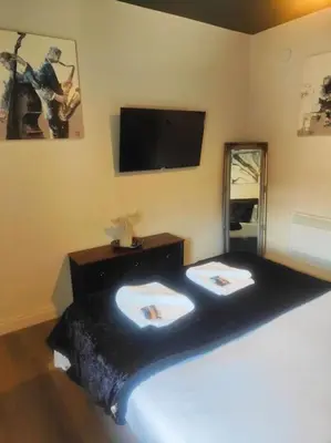 a bedroom with a bed with a tv on the wall at Sloane modern 2 bedroom seafront Apartment in Blackpool