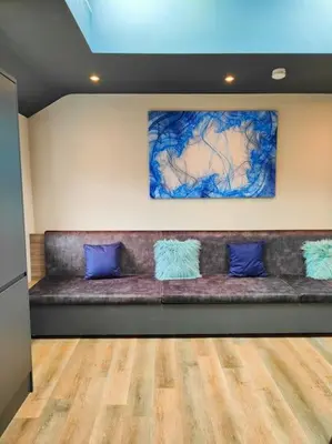 a couch with blue pillows sitting in a room at Sloane modern 2 bedroom seafront Apartment in Blackpool