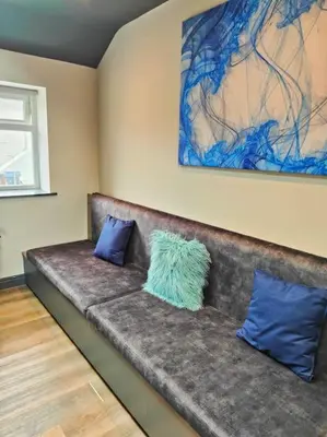 a couch with two blue pillows on it in a room at Sloane modern 2 bedroom seafront Apartment in Blackpool