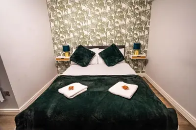 a bedroom with a bed with two towels on it at Belgravia Duplex Seaview Apartment in Blackpool