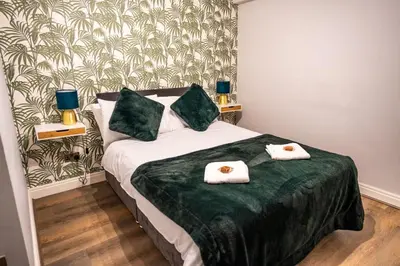 a bedroom with a bed with two towels on it at Belgravia Duplex Seaview Apartment in Blackpool