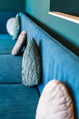 a blue couch with two pillows on it at Belgravia Duplex Seaview Apartment in Blackpool