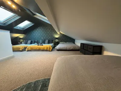 a bedroom with two beds and a ceiling at Belgravia Duplex Seaview Apartment in Blackpool