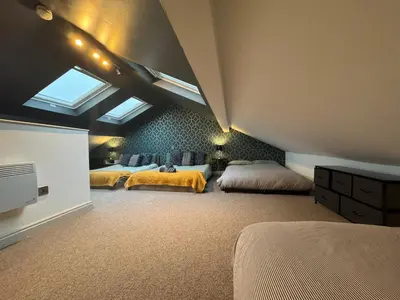 a attic bedroom with two beds and a skylight at Belgravia Duplex Seaview Apartment in Blackpool
