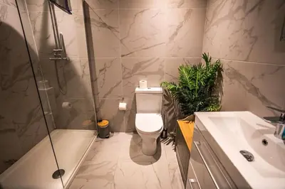 a bathroom with a toilet and a shower and a sink at Belgravia Duplex Seaview Apartment in Blackpool