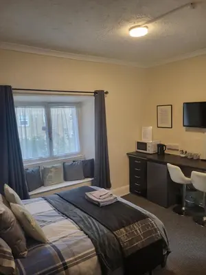 a bedroom with a bed and a desk and a window at Station Guesthouse - Self entry via keypad inc parking in Lancaster