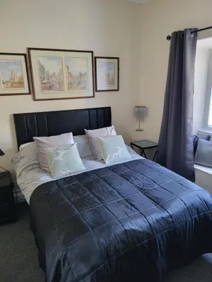 a bedroom with a large bed with blue sheets and pillows at Station Guesthouse - Self entry via keypad inc parking in Lancaster