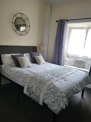 a bedroom with a large bed with a window at Station Guesthouse - Self entry via keypad inc parking in Lancaster