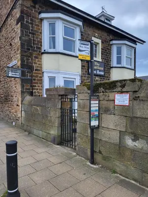 a street sign in front of a brick building at Station Guesthouse - Self entry via keypad inc parking in Lancaster