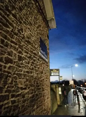 a brick building with a sign on the side of it at Station Guesthouse - Self entry via keypad inc parking in Lancaster