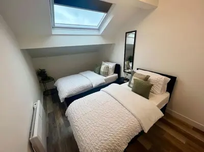 two beds in a room with a window at 2 Bed Preston City Centre Flat - Sleeps 4 with parking in Preston