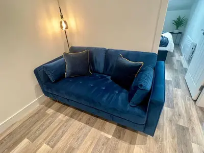 a blue couch with two pillows sitting in a living room at 2 Bed Preston City Centre Flat - Sleeps 4 with parking in Preston