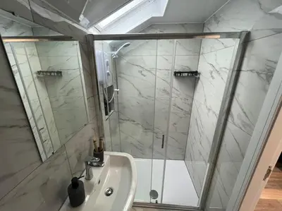 a white bathroom with a shower and a sink at 2 Bed Preston City Centre Flat - Sleeps 4 with parking in Preston