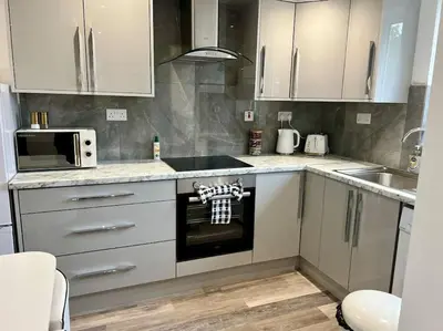 a kitchen with white cabinets and a stove top oven at 2 Bed Preston City Centre Flat - Sleeps 4 with parking in Preston