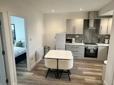 a kitchen with a white table and a white refrigerator at 2 Bed Preston City Centre Flat - Sleeps 4 with parking in Preston