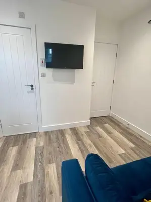a living room with a blue couch and a flat screen tv at 2 Bed Preston City Centre Flat - Sleeps 4 with parking in Preston