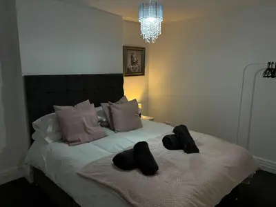 a bedroom with a bed with two black slippers on it at Apartment Twenty4 Blackpool in Blackpool