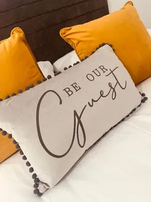 a pillow with the words be our guest on a bed at Apartment Twenty4 Blackpool in Blackpool