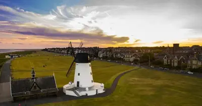 a lighthouse in a field next to a city at Luxe 6 berth caravan Lytham in Weeton