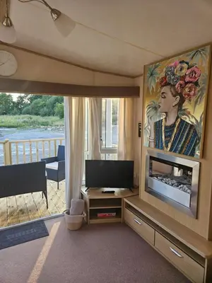 a living room with a television and a balcony at Luxe 6 berth caravan Lytham in Weeton