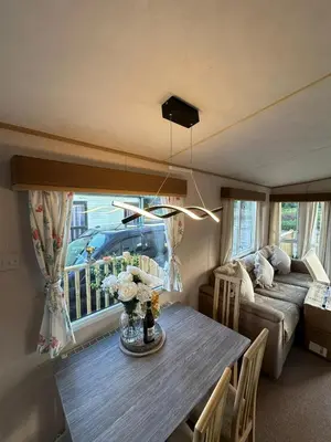 a living room with a table and a couch at Luxe 6 berth caravan Lytham in Weeton