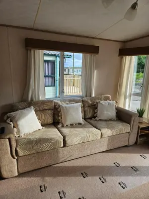 a brown couch in a living room with a window at Luxe 6 berth caravan Lytham in Weeton
