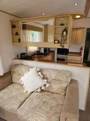 a couch in a room with a kitchen at Luxe 6 berth caravan Lytham in Weeton