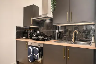 a kitchen with gray cabinets and a sink at Lombana Apt 4 - City Centre - Parking in Liverpool