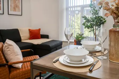 a living room with a table with plates and wine glasses at Lombana Apt 4 - City Centre - Parking in Liverpool