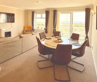 a living room with a table and chairs and a couch at The Beachcomber - seafront, free parking, free wifi in Cleveleys