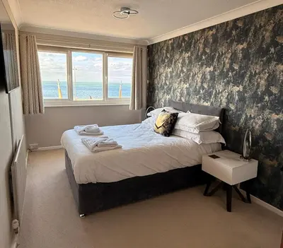 a bedroom with a bed with a view of the ocean at The Beachcomber - seafront, free parking, free wifi in Cleveleys